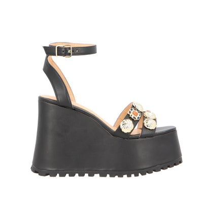 Black wedge sandal with floral embellishments on a white background