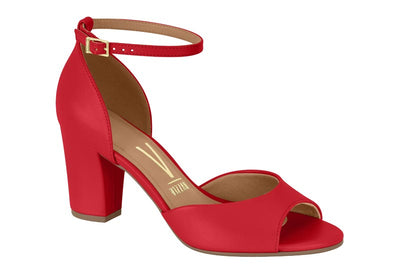 Red high-heeled sandal with a gold buckle on a white background