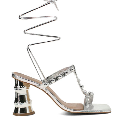 Silver high-heeled sandal with unique design on a white background